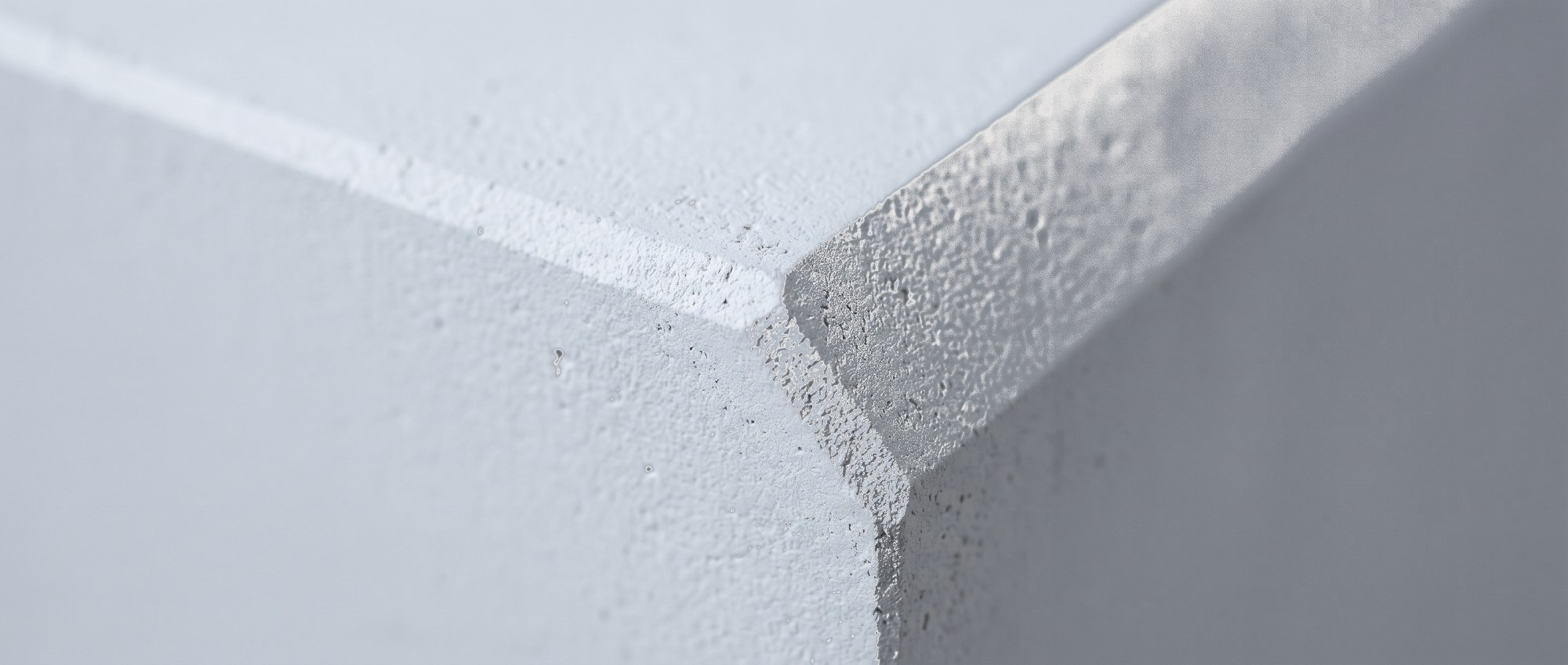 Macro of a chamfered edge on a pale grey form.