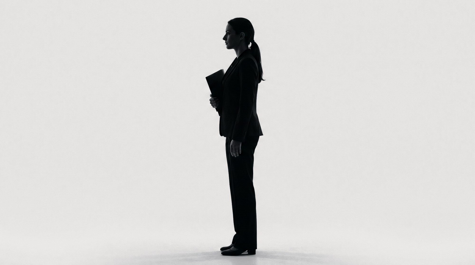 Silhouette of a financial adviser standing with a folder under one arm.